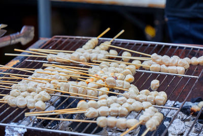 People grilling skewer meatball on barbecue grill