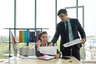 Man working on table by window