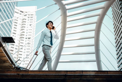 Low angle view of woman standing on staircase against building