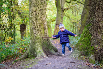 Full length of smiling boy in forest