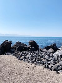 Rocks on beach against clear sky