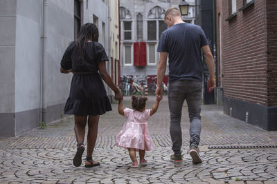 A young family walking through the streets of a european city