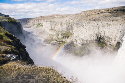 Scenic view of waterfall against sky