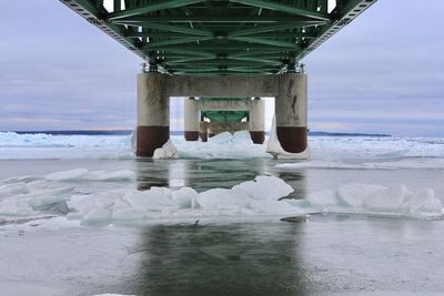 Bridge over sea against sky during winter