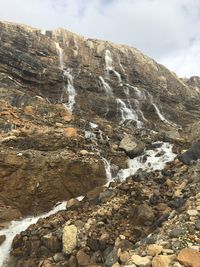 Scenic view of waterfall against sky