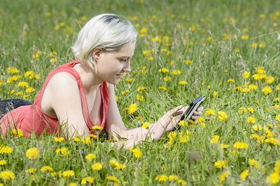 Woman with yellow flowers on field