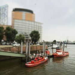 Boats in river with city in background