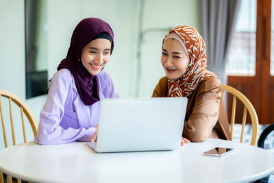 Young woman using laptop at table