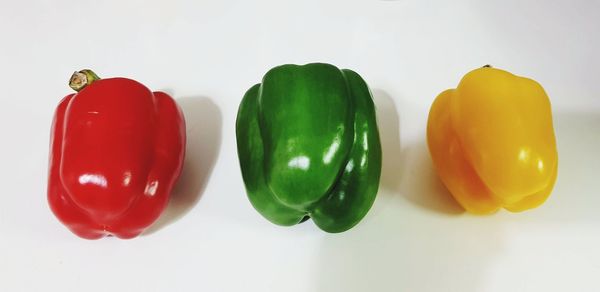 Close-up of multi colored bell peppers against white background