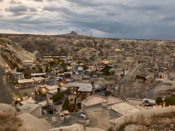 Cave houses and volcanic landscape of goreme and uchisar castle at the horizon in the evening 