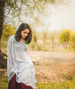 Young woman in traditional clothing standing on field