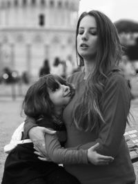 Mother embracing daughter on footpath