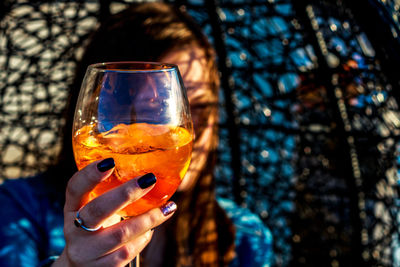 Close-up of woman holding cocktail in glass