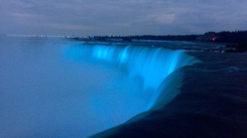 Scenic view of waterfall against sky during winter