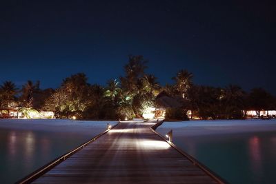 Swimming pool against clear blue sky at night