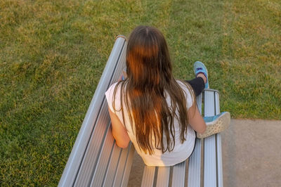 Rear view of woman sitting on grass