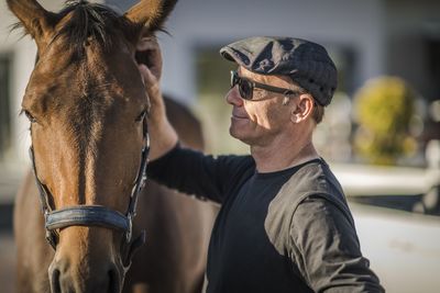 Portrait of man with horse outdoors