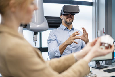 Businessman and businesswoman withvr glasses and workpiece in factory