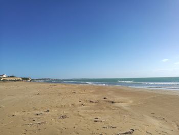 Scenic view of beach against clear blue sky