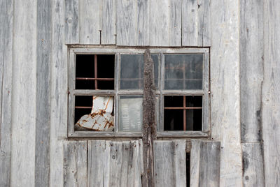 Old small window in abandoned wood wall. sign mill premises