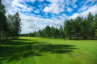 Scenic view of golf course against sky