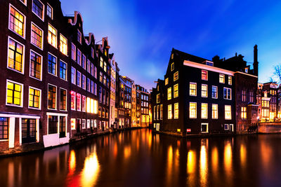 Reflection of buildings in canal at night