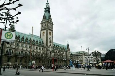 People in city against cloudy sky