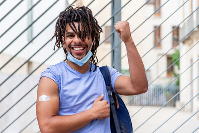 Young latin man vaccinated showing his arm