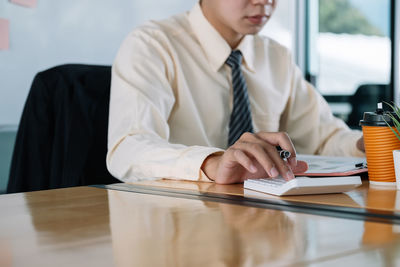 Midsection of businessman working on table