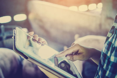 Midsection of man using digital tablet