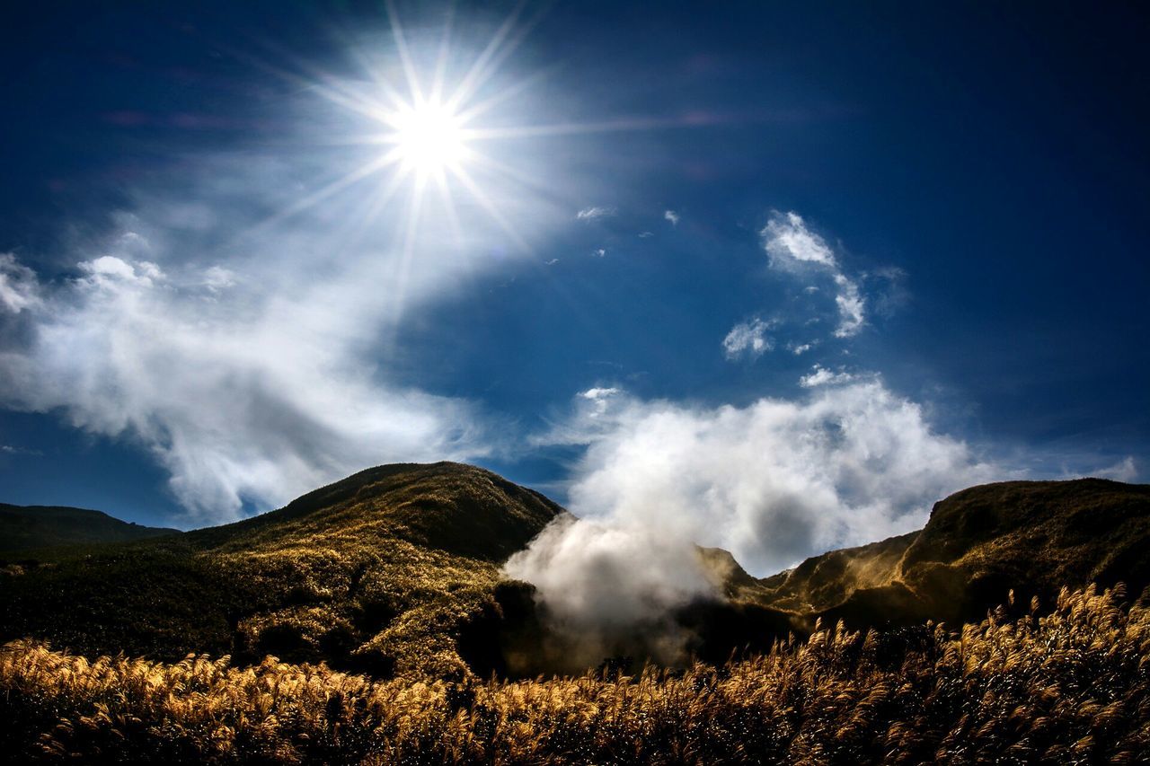 mountain, tranquil scene, tranquility, scenics, beauty in nature, sky, landscape, mountain range, nature, sunbeam, sunlight, sun, cloud - sky, non-urban scene, idyllic, blue, lens flare, cloud, remote, majestic