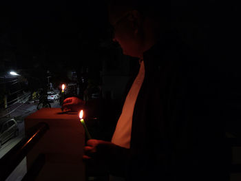 Midsection of woman standing on illuminated table