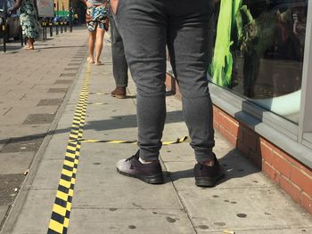 Low section of people walking on footpath in city