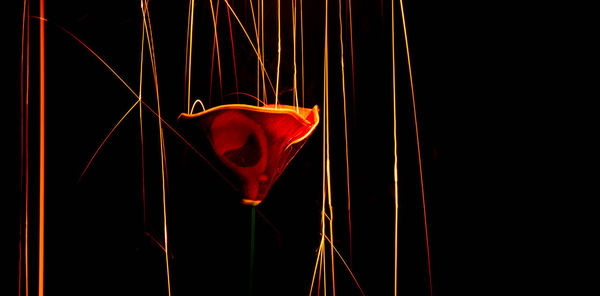 Close-up of illuminated lighting equipment against black background