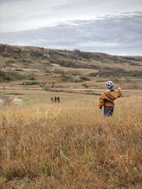 Rear view of woman standing on field