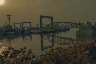 Bridge over river against sky during sunset