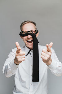 Portrait of man wearing hat standing against gray background