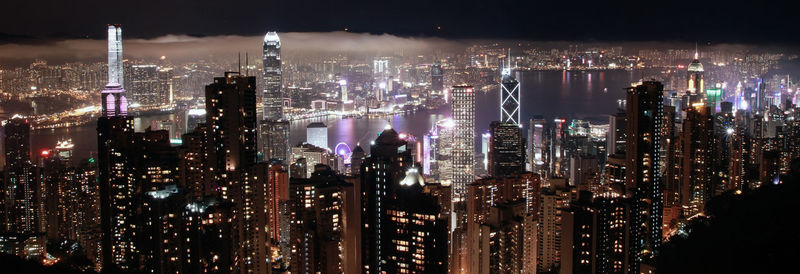 Illuminated cityscape against sky at night