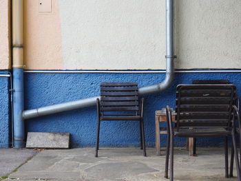 Empty chairs against wall in building