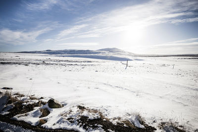 Scenic view of snow covered land against sky