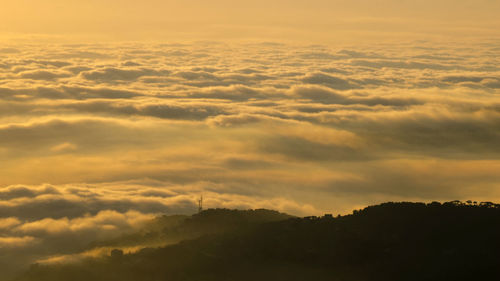 Scenic view of clouds over mountains during sunset