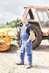 Senior man in front of tractor, smaland, sweden