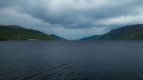Scenic view of lake by mountain against sky