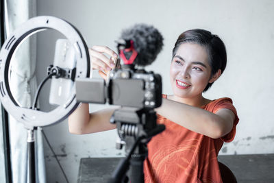 Portrait of smiling woman with camera