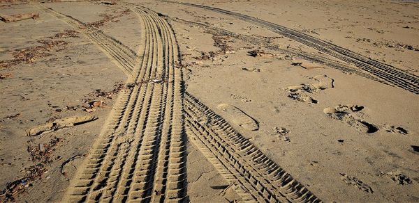 High angle view of tire tracks on sand