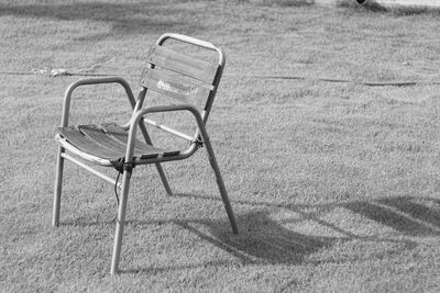 High angle view of empty chairs on field during sunny day