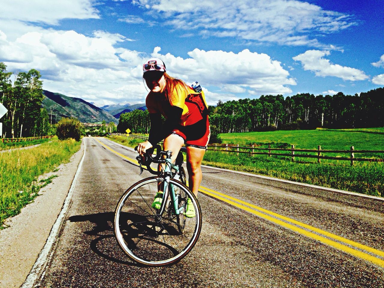 transportation, bicycle, land vehicle, road, mode of transport, sky, the way forward, riding, lifestyles, full length, leisure activity, landscape, cloud - sky, cycling, diminishing perspective, travel, rear view, country road