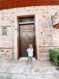 Boy standing by door of building