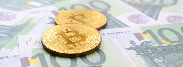 Close-up of bitcoins on paper currency