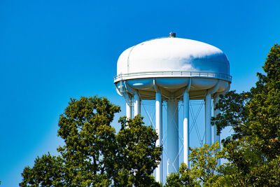 Low angle view of water tower against clear blue sky